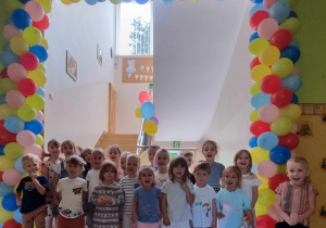 Montessoriaki pozują na tle bramy balonowej