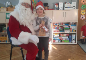 Dziewczynka z grupy Daltonki pozuje ze Świętym Mikołajem