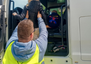 Pan kierowca wsadza dziecko na fotel pojazdu