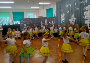 Dziewczyki tańczą układ ze wstążkami na patyczkach do utworu ABBY ,,Money, money"