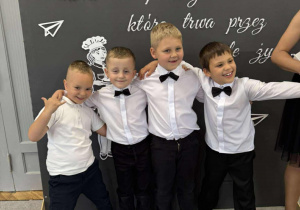 Czterech chłopców pozuje na tle dekoracji