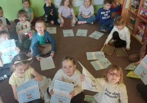 Dzieci pozują z książkami ich rodziców