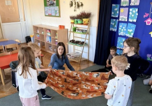 Dzieci rozkładają kocyk dla pieska