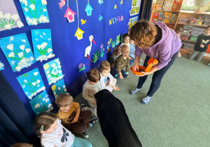 Dzieci podają pieskowi ulubiony przysmak