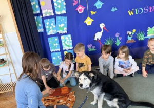 Dzieci nalewają pieskowi wody do miski