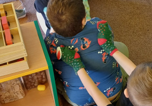 Dzieci siedzą w kole i wykonują masaż