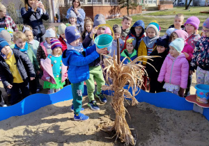 Chłopiec polewa wodą marzannę