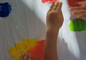 Dzieci malują kropki farbami za pomocą dłoni