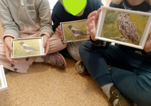 Dzieci trzymają ramki ze zdjęciami ptaków