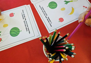 Dzieci wykonują kartę pracy przy stoliku