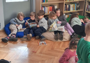 Dzieci oglądają książki o dinozaurach