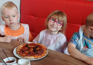Dziewczynka prezentuje swoją pizzę