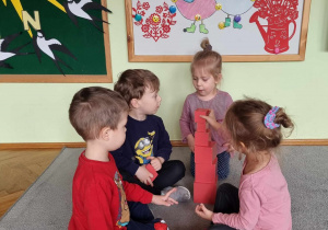 Dzieci układają różową wieżę wg pedagogiki M. Montessori