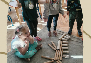 Dzieci prezentują szkielety dinozaurów wykonane z rolek papierowych