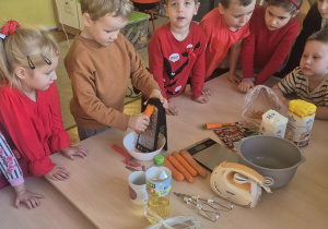 Chłopiec ściera marchewkę na tarce