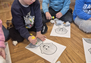 Dzieci przyklejają brodę św. Mikołaja