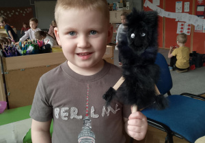 Chłopiec trzyma kukiełkę wilka