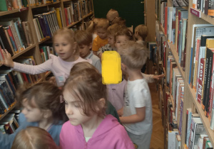 Dzieci oglądają książki na regałach