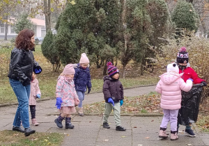 Dzieci razem z panią Agnieszką sprzątają osiedle