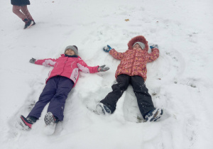Dziewczynki robią aniołki na śniegu