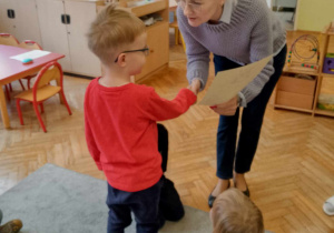 Dyrektor przedszkola gratuluje chłopcu z grupy Montessoriaki