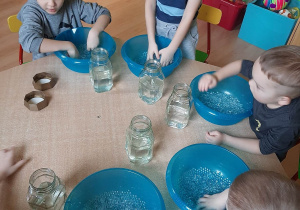 dzieci łączą hydrokulki z wodą