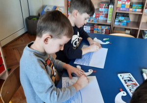 Chłopcy rysują staw za pomocą kredek pastelowych