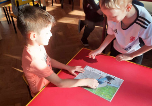 Chłopcy układają puzzle przedstawiające wronę