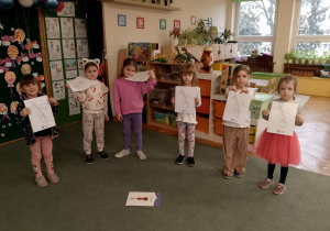 Dziewczynki trzymają obrazki skrzypiec