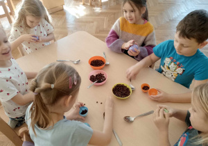 Dzieci wypełniają plastikowe jajeczka ziarnami kawy