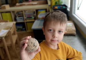 Chłopiec pokazuje kulę z ziarnami