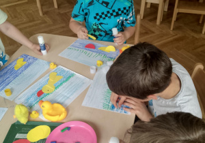 Chłopcy komponują kaczkę z kół origami