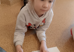 Dziewczynka koloruje łabędzia i robi tło