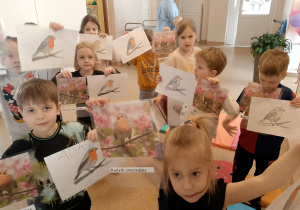 Dzieci z kolorowankami i zdjęciami rudzika