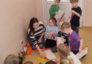 Dzieci robią ogon kogutowi z bibuły