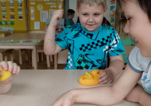 Chłopcy bawią się gumowymi kaczkami