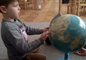 Chłopiec szuka na globusie Antarktydy