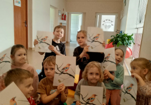 Dzieci z ilustracjami przedstawiającymi sójkę