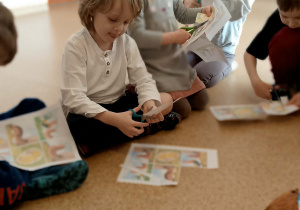 Dzieci wycinają obrazki historyjki obrazkowej o rodzinie kury