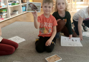 Chłopiec pokazuje ramkę ze zdjęciem wróbla