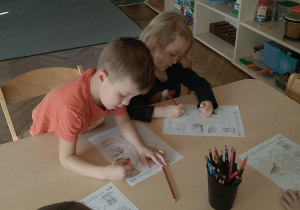 Chłopcy wykonują kartę pracy - gniazda ptaków