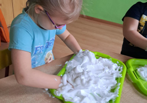 Dziewczynka bawi się pianką do golenia